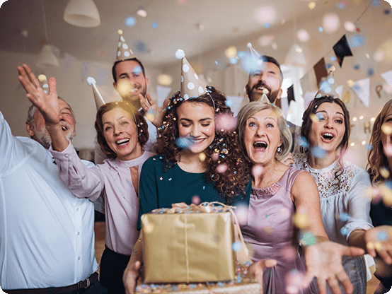 Gruppe von Geburtstagsgästen überreicht ein Geschenk