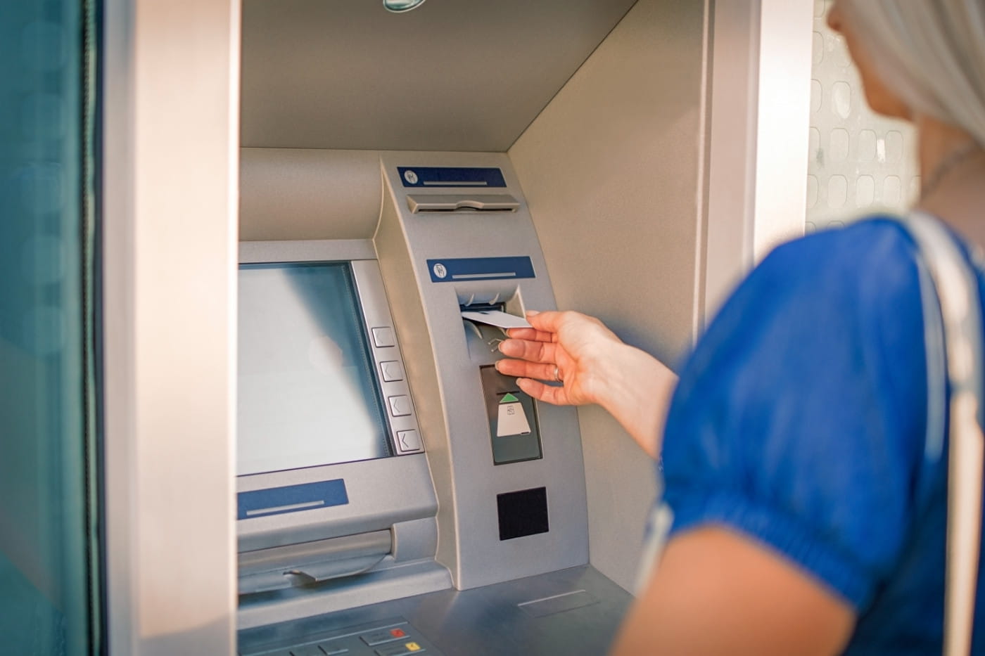 person-hebt-geld-vom-geldautomat-ab-adecco