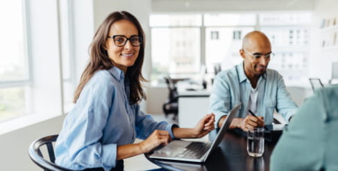 sales-consultant-laechelnde-frau-sitzt-mit-laptop-im-buero-adecco