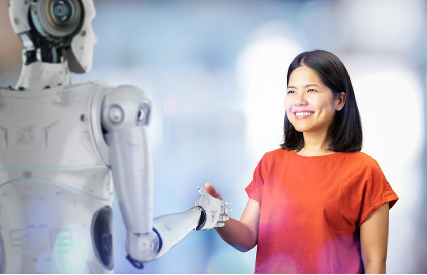 Frau und Roboter schütteln sich die Hand.