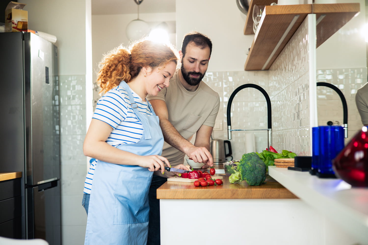 Frau und Mann kochen mit Gemüse.