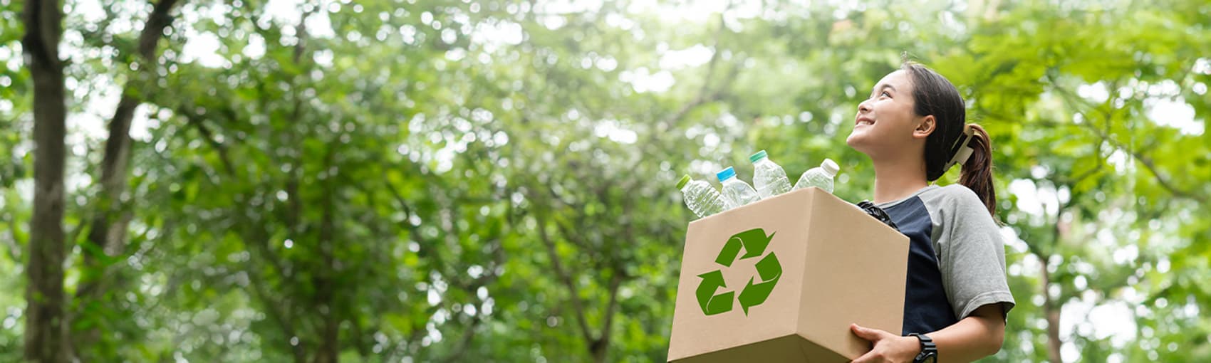 Glückliche Frau mit einem recycelten Karton in der Hand